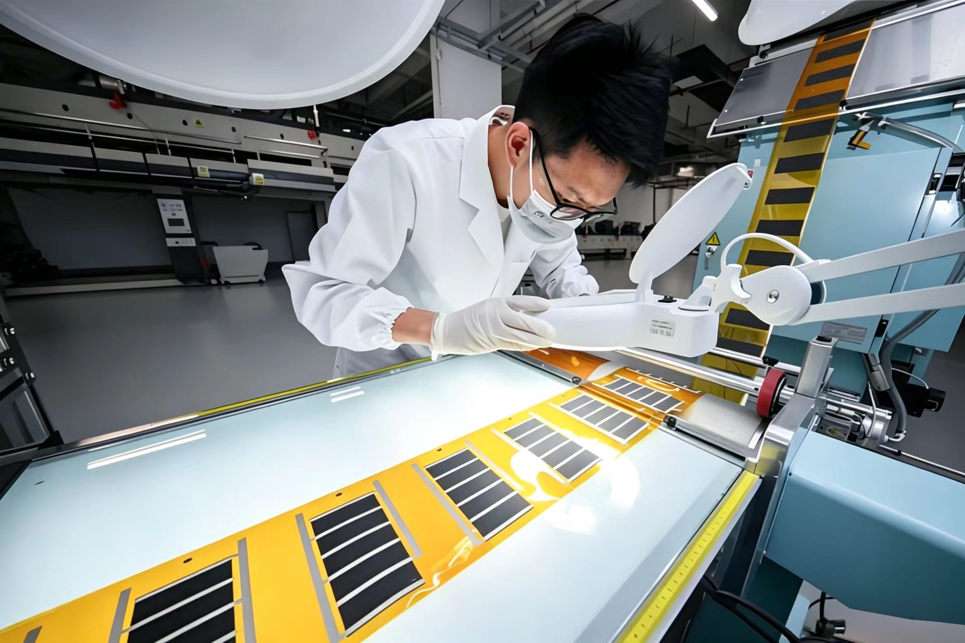 Engineer inspecting graphene film at IKKEM production line