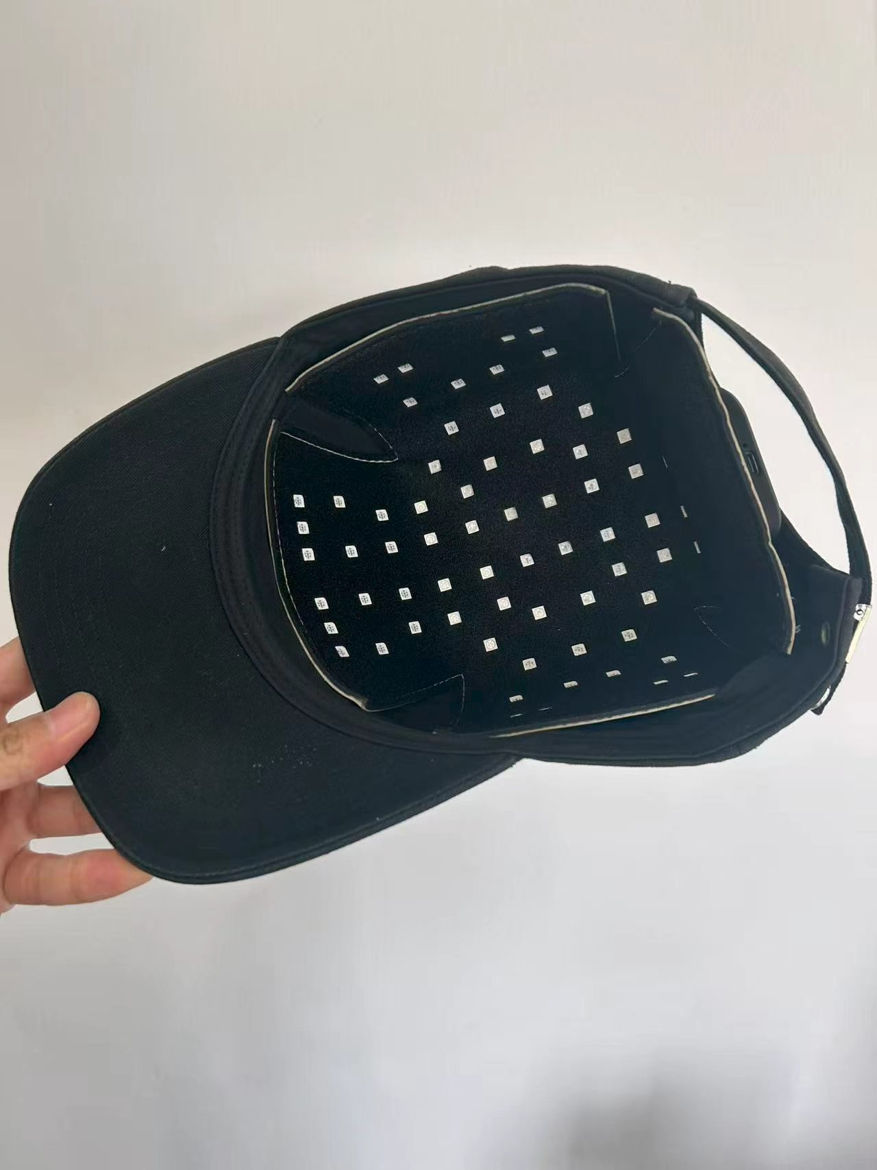 Hair-care pad fitted inside a black baseball cap