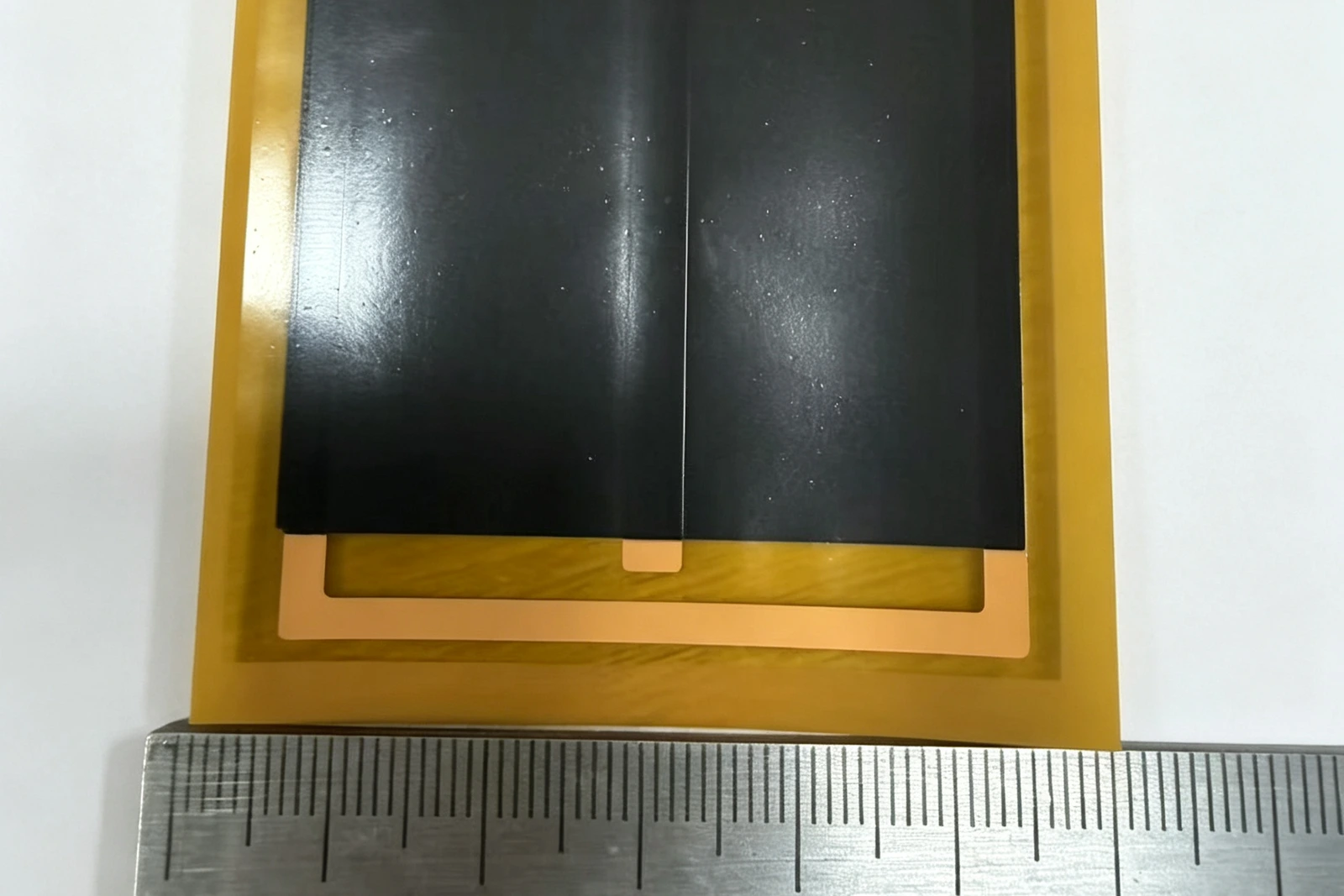 XIHE PI-encapsulated graphene heating-film sample shown beside a dimensional reference